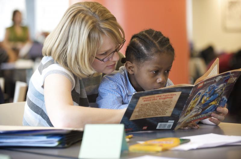 Adult helping child to read